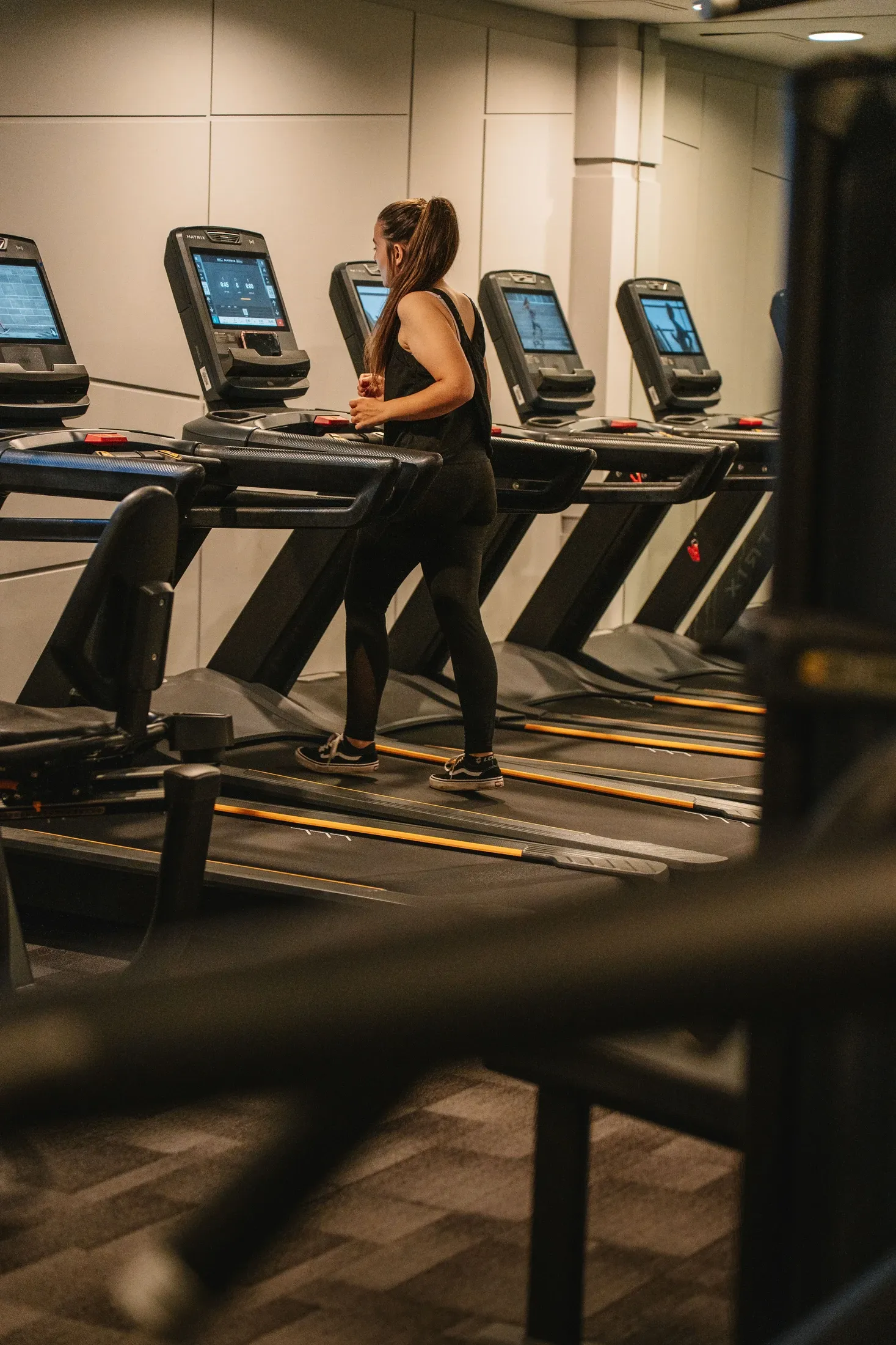 Modern spor salonunda koşu bandında kardiyo antrenmanı yapan kadın